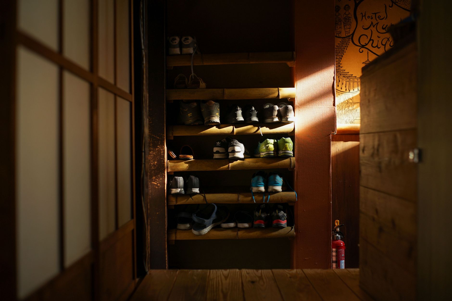 Why Japanese People Take Their Shoes Off at the Door — Japanese home entryway with genkan step, shoes neatly facing the door, slippers on a shelf