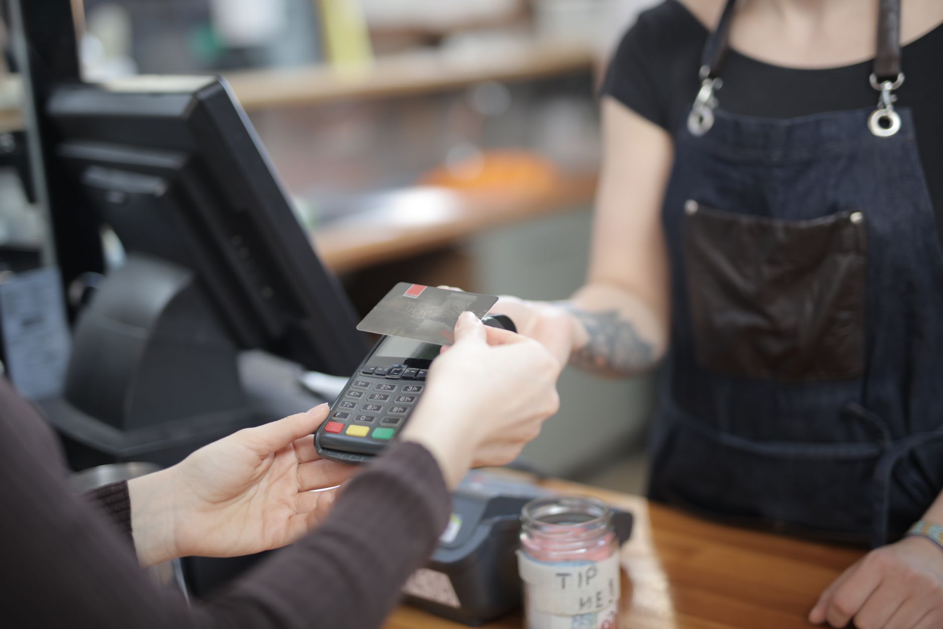 How a Japanese Convenience Store Is Different From an American One — Japanese convenience store checkout counter with clerk serving coffee and customer paying a utility bill