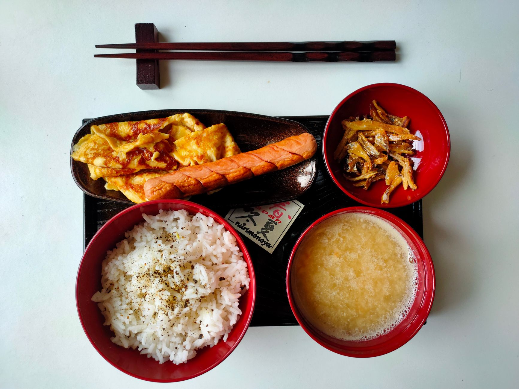 What a Typical Japanese Breakfast Looks Like — simple Japanese breakfast table with bowl of rice, miso soup, grilled fish, pickles, and green tea